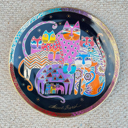 Decorative plate with colorful cat designs on a textured surface