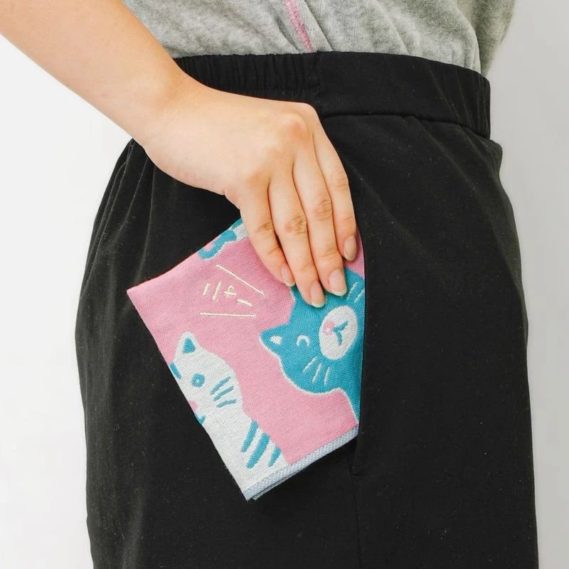 Person holding a pink and blue cat-themed pocket square 