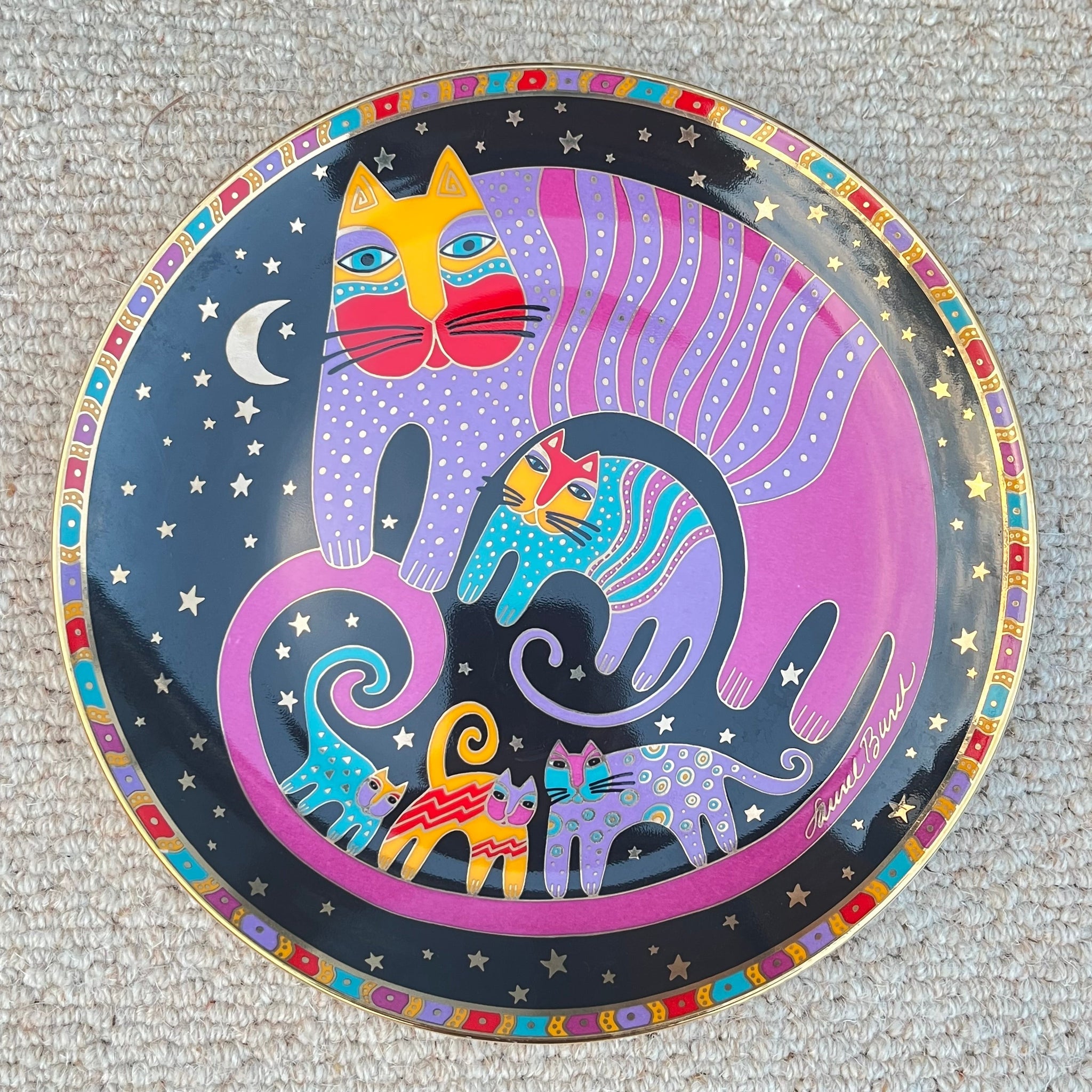 Decorative plate with colorful cat design on a textured surface
