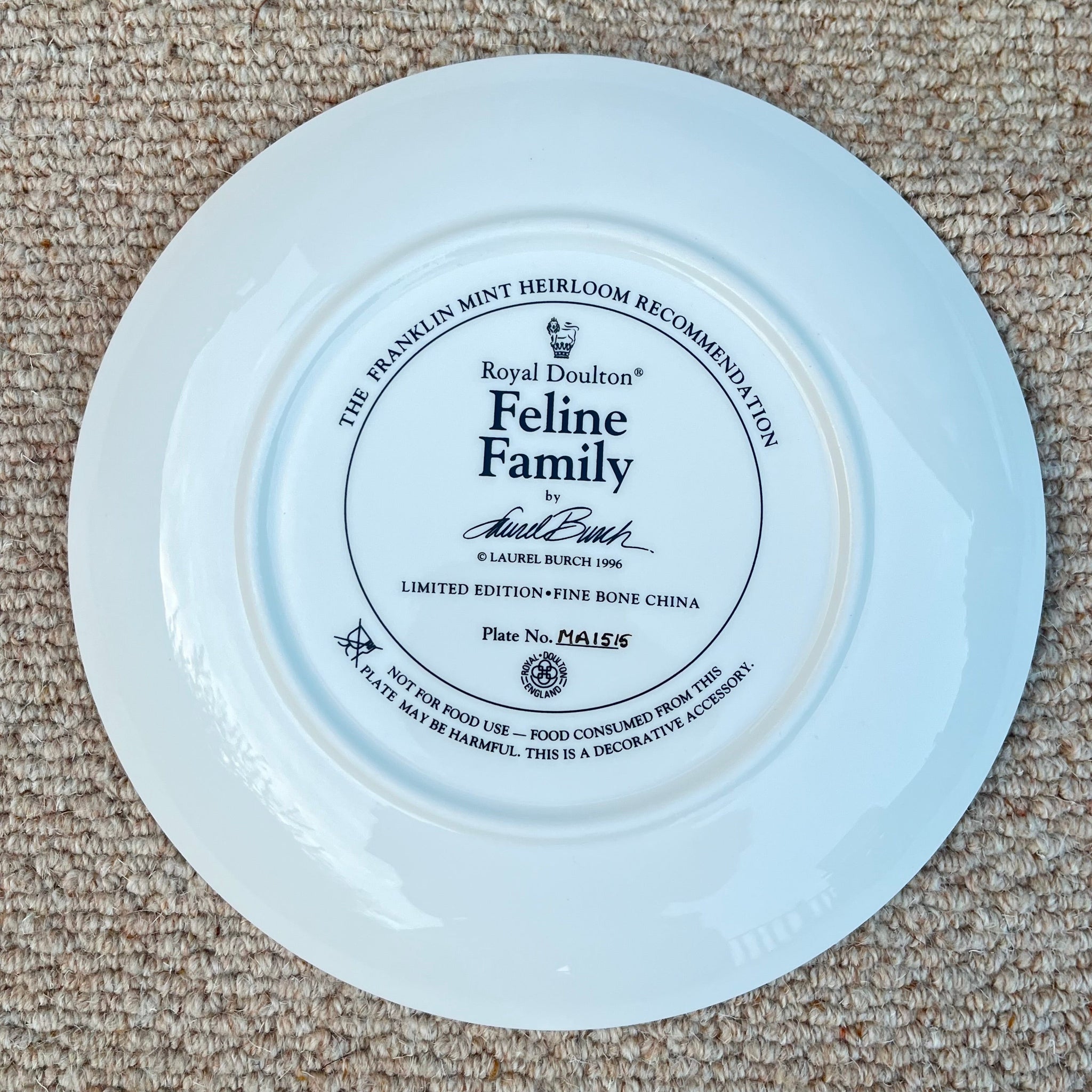 White plate with a decorative black label on a beige carpet
