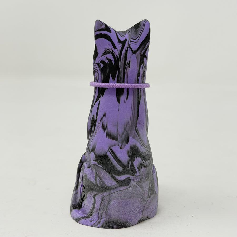 A purple and black marbled cat figurine wearing a purple collar with a gold initial 'P' charm, set against a plain light grey background. Rear view.