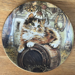 Decorative plate with a cat design on a wooden surface