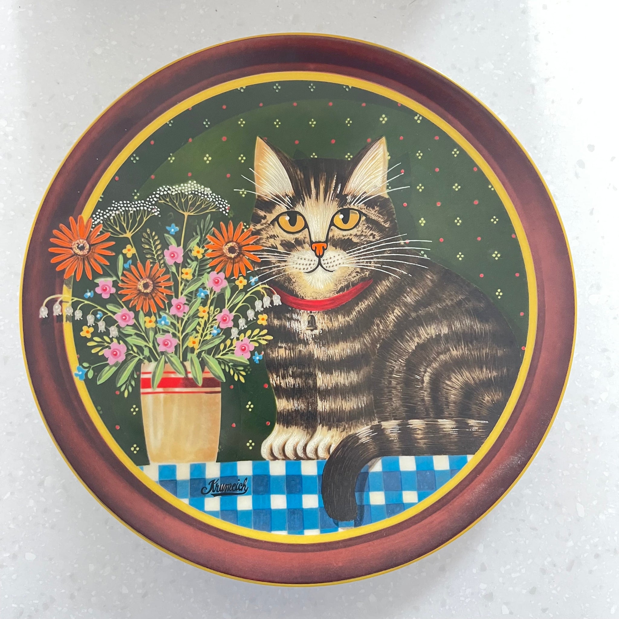 Decorative plate with a cat and floral design on a white background