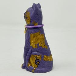 A purple lucky cat ornament with gold foil accents and lilac collar with P charm - side view