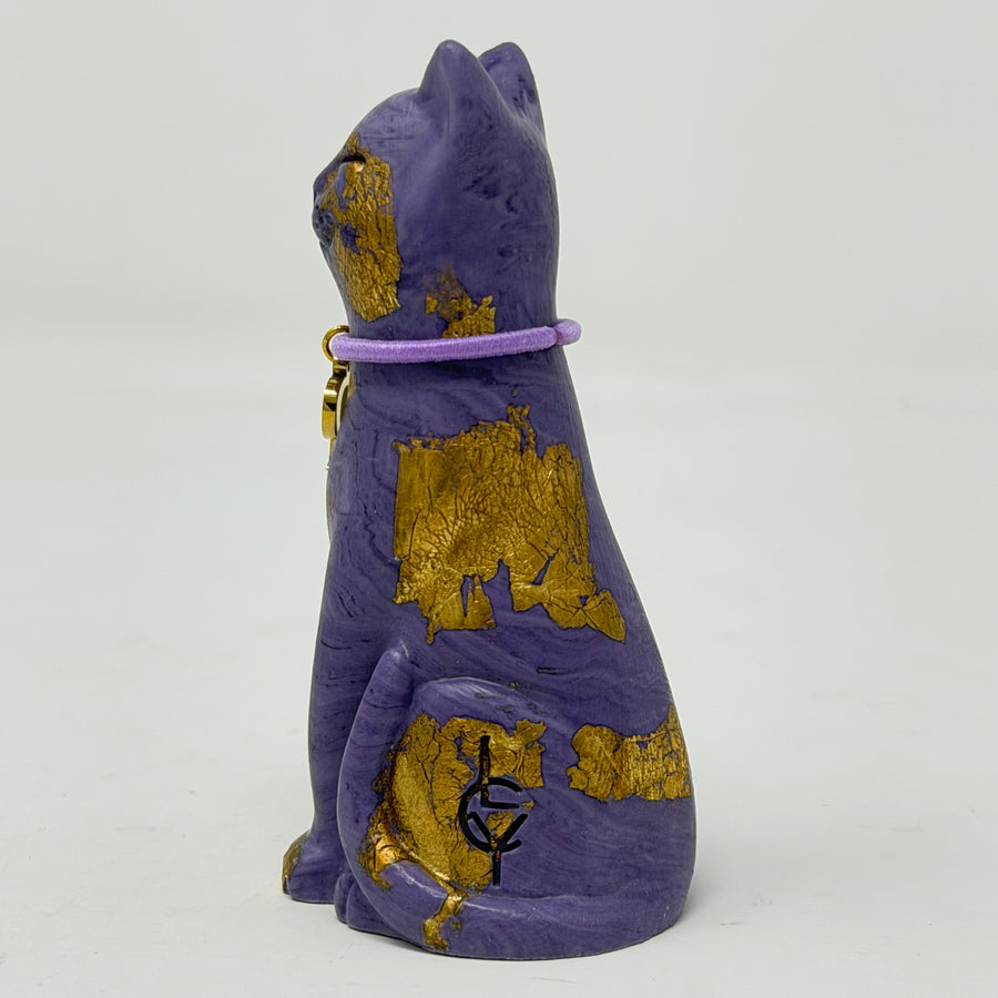 A purple lucky cat ornament with gold foil accents and lilac collar with P charm - side view