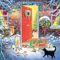Winter scene with a red door, gifts, cats and a robin in a snowy setting.