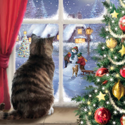 Striped tabby cat looking out a window at a snowy scene with Christmas decorations on a tree.