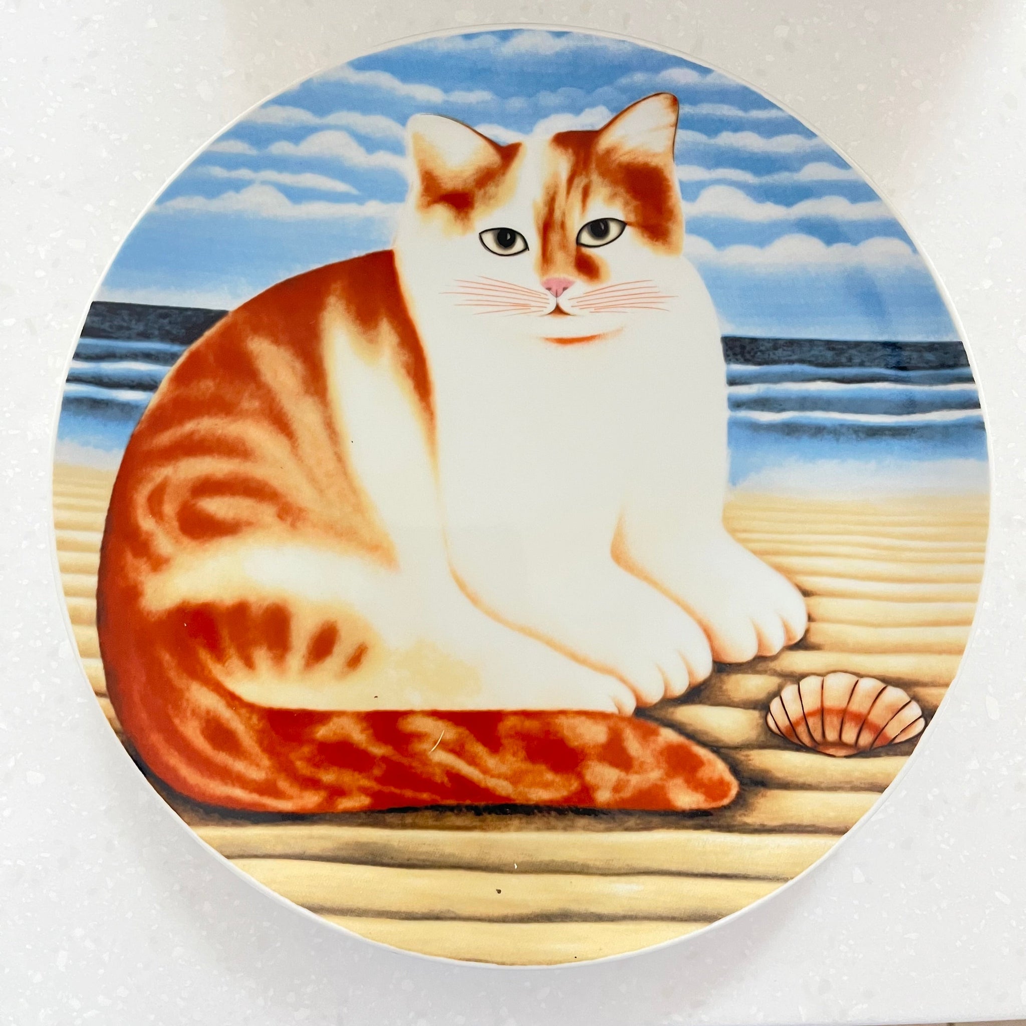 Round ceramic plate with a cat design on a white background