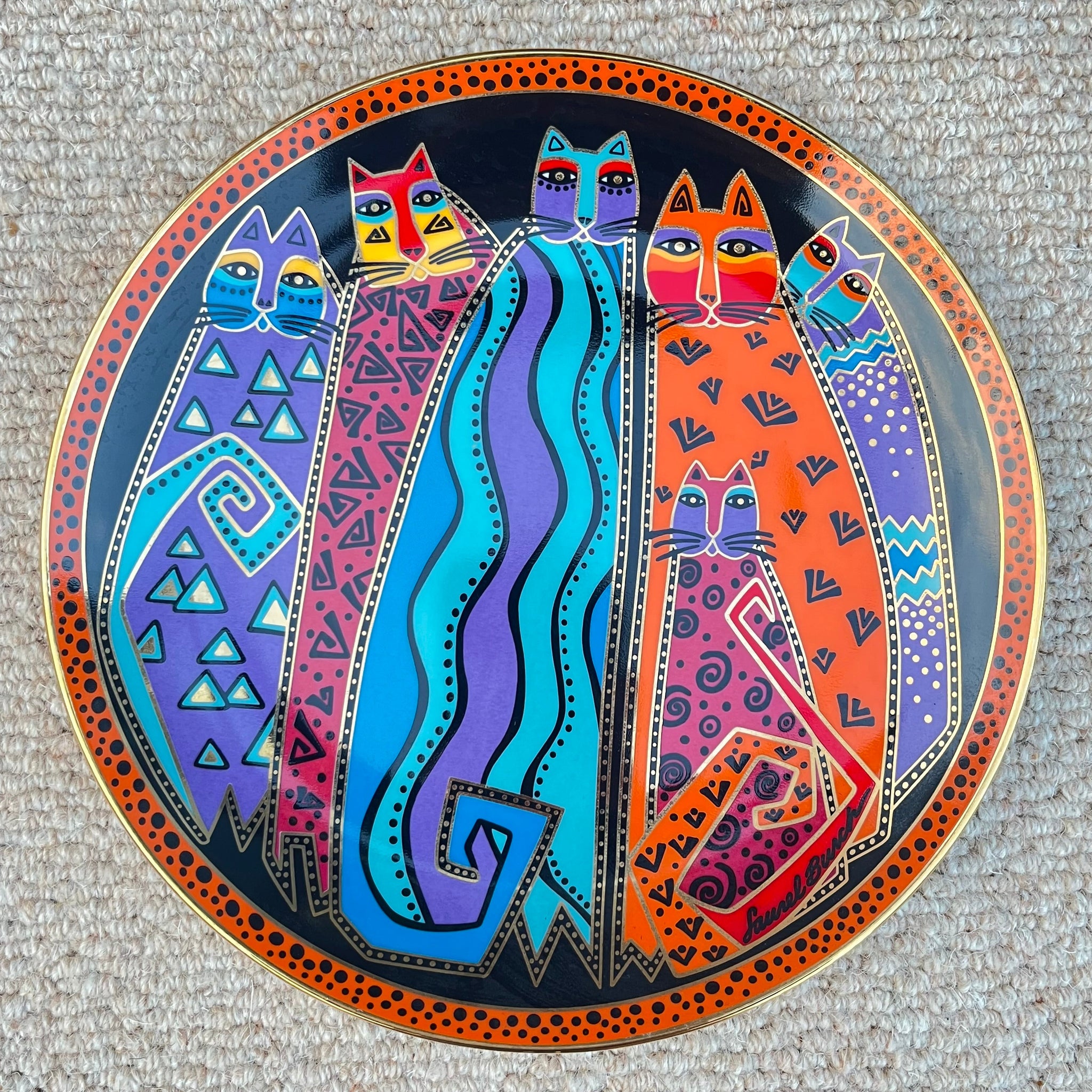 Decorative plate with colorful abstract designs on a textured surface