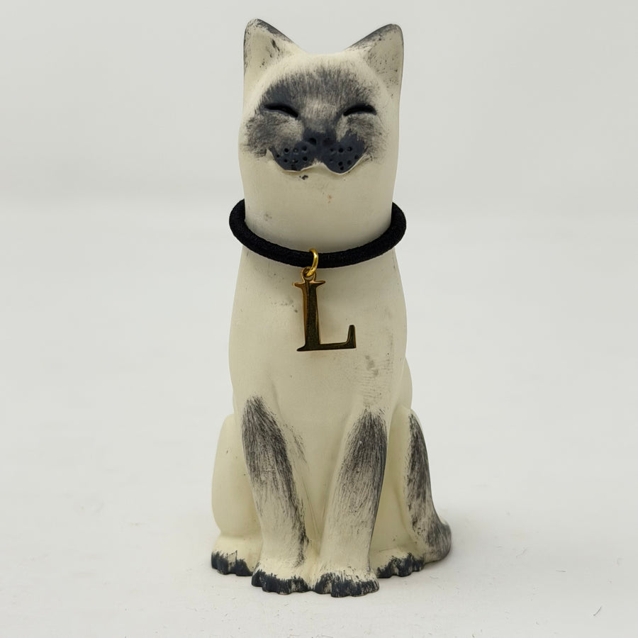 A  Lucky Cat figure hand painted to look like a blue point Siamese with a navy collar and L charm. Front view.
