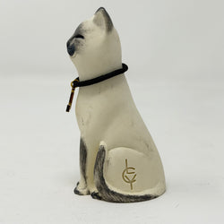 A  Lucky Cat figure hand painted to look like a blue point Siamese with a navy collar and L charm. Side view.