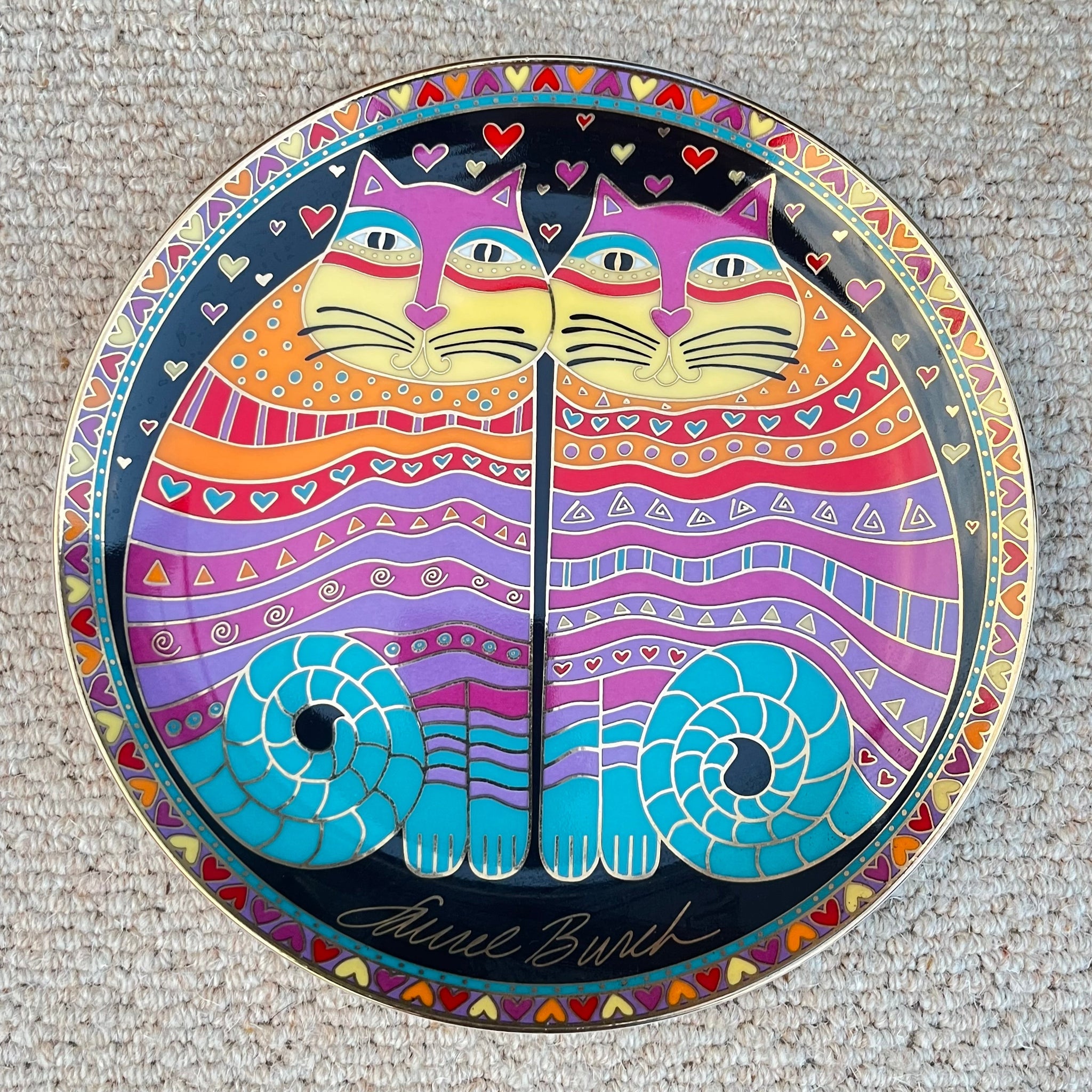 Colorful decorative plate with cat design on a textured surface