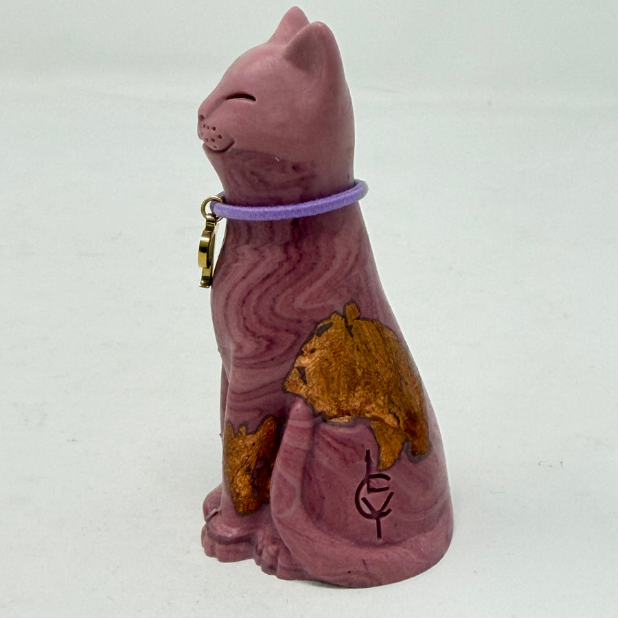 A marbled aubergine-coloured lucky cat figurine wearing a purple collar with a gold letter 'P' charm, set against a plain light grey background. Side view.