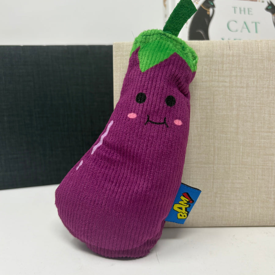 A cute eggplant-shaped plush cat toy made of purple corduroy fabric with a green top and embroidered face,