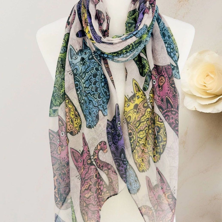 A lightweight scarf featuring a pattern of stylised cat silhouettes filled with intricate mandala-like designs in multiple colours