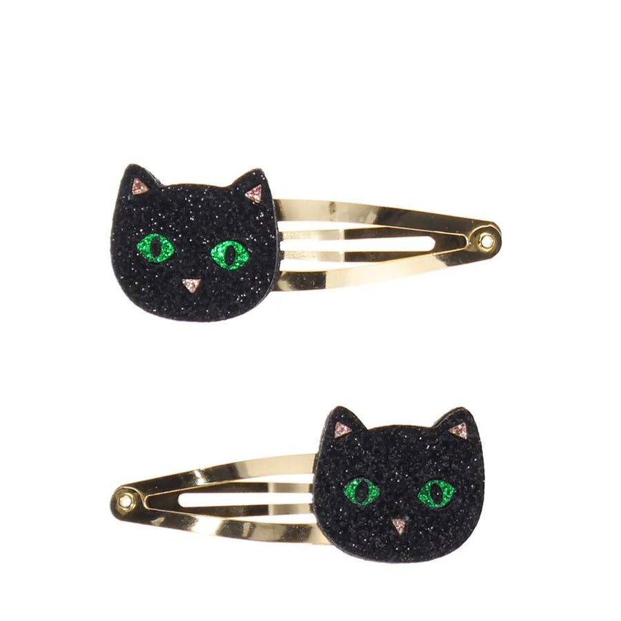 Two black glitter cat hair clips with green eyes and gold-tone metal bars, shown on a plain white background.