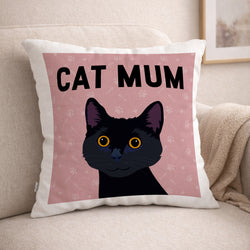 Decorative cushion with a black cat illustration and 'CAT MUM' text on a pink background, placed on a beige couch.