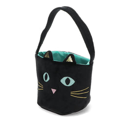 A black plush bucket bag designed like a cat's face, featuring embroidered light blue eyes, a pink nose, yellow whiskers, and a teal interior lining with gold triangular ear accents