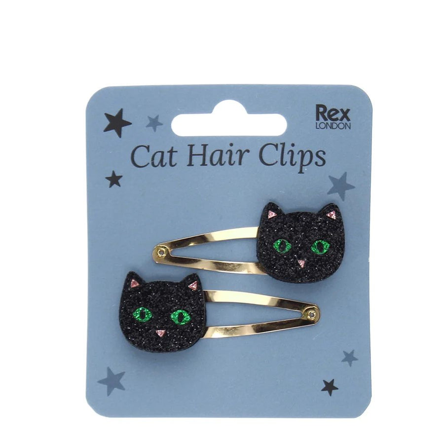 Two black glitter cat hair clips with green eyes and pink nose details, attached to a light blue card labeled 'Cat Hair Clips'