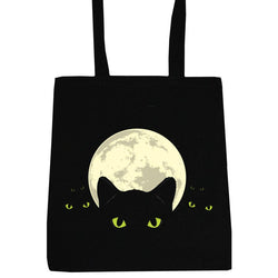 A black canvas tote bag with a graphic of a black cat silhouette in front of a large cream-colored full moon, featuring small glowing green eyes