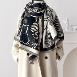 Scarf with black and white cat patterns draped over a beige coat on a mannequin