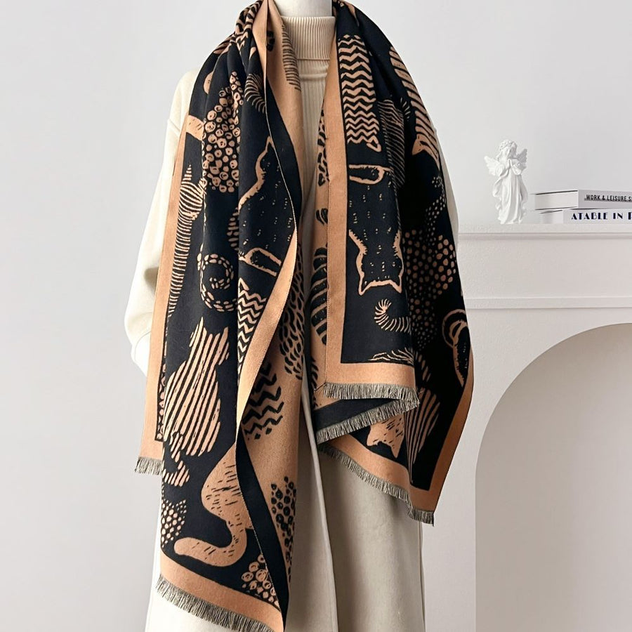 Black and beige cat patterned scarf on a mannequin against a white background