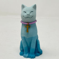 A light blue ombre lucky cat figurine wearing a lavender collar with a gold letter 'T' charm