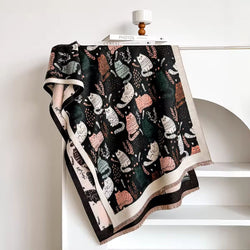 Patterned blanket with cat designs draped over a chair