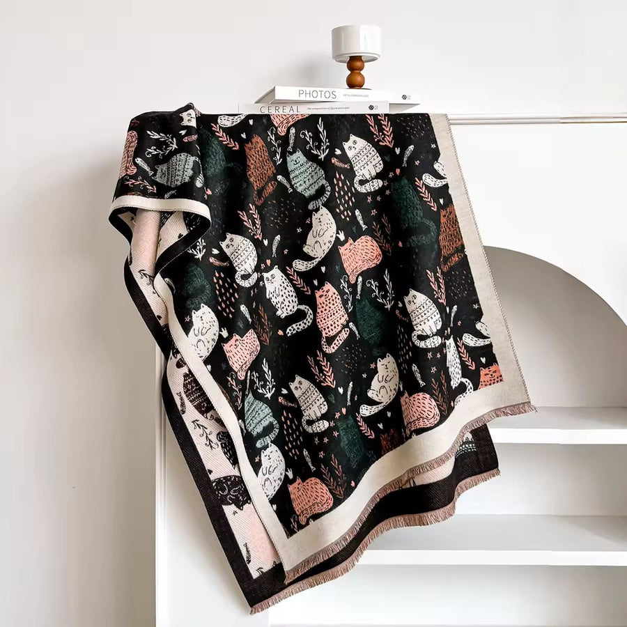 Patterned blanket with cat designs draped over a chair
