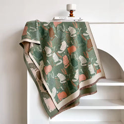 Decorative green fabric with cat pattern on a white surface