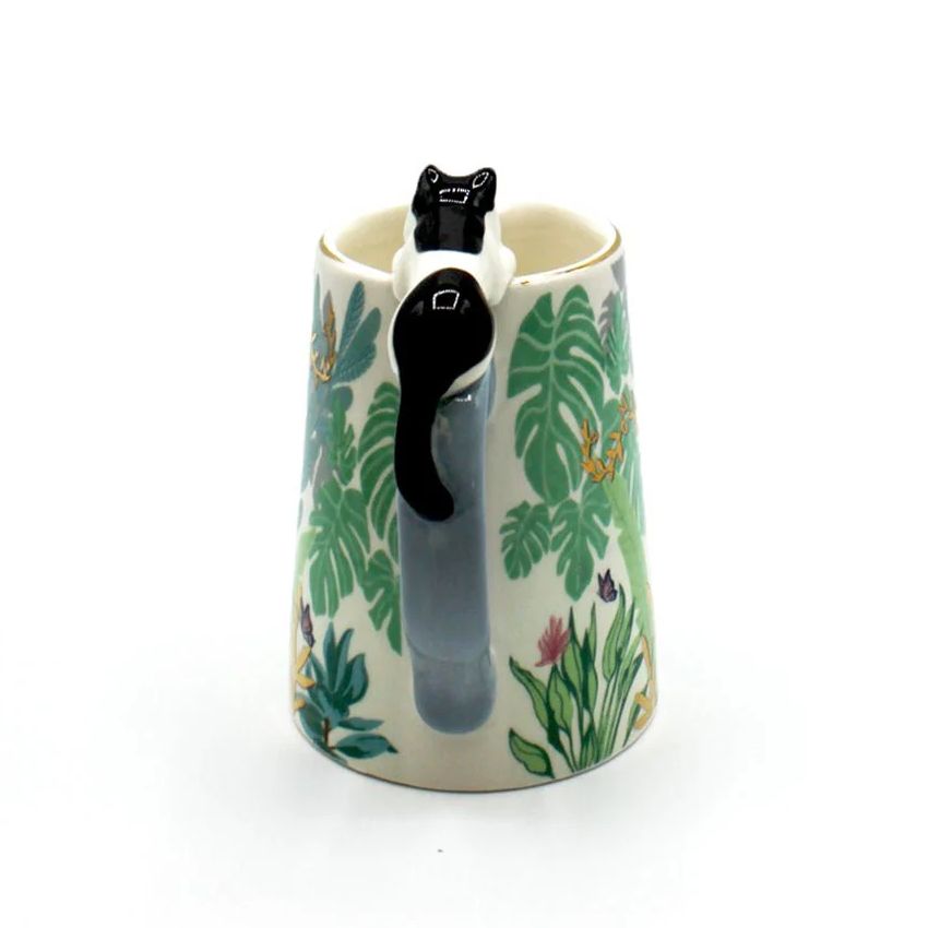 Ceramic mug with a cat design and leaf pattern on a white background