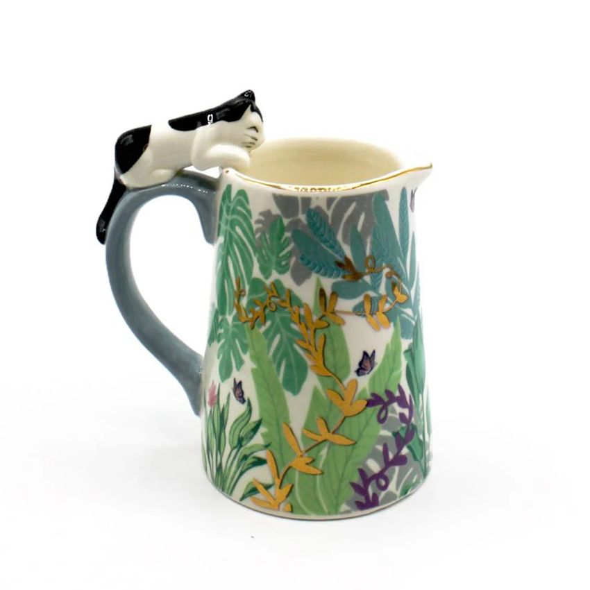 Decorative mug with a cat design on the handle against a white background