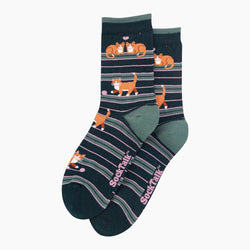 A pair of dark navy crew socks with horizontal stripes in gray, olive green, and pink, featuring cartoon orange tabby cats