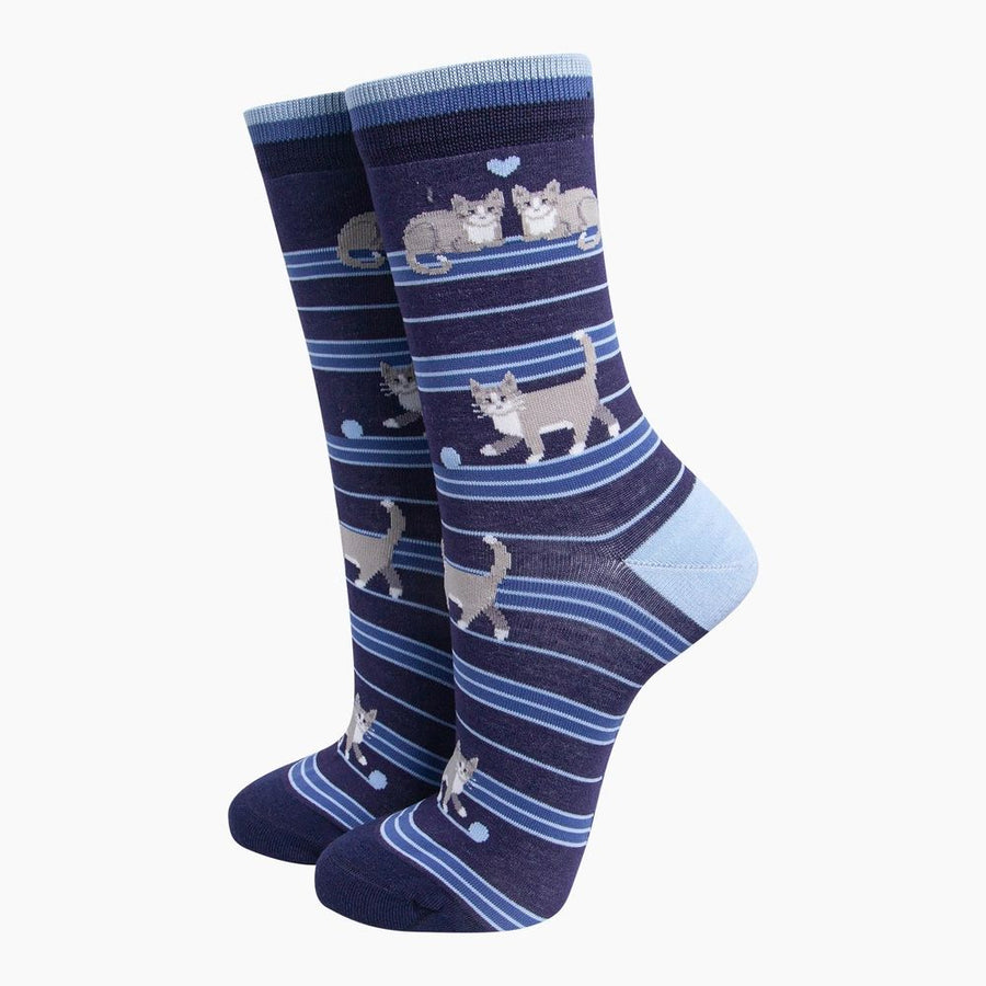 A pair of navy blue crew socks with light blue stripes and cartoon cat illustrations, shown against a plain white background.