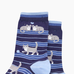 A pair of navy blue crew socks with a pattern of gray and white cats on horizontal blue stripes