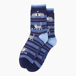 A pair of navy blue crew socks with light blue stripes and a playful pattern of grey and white cats