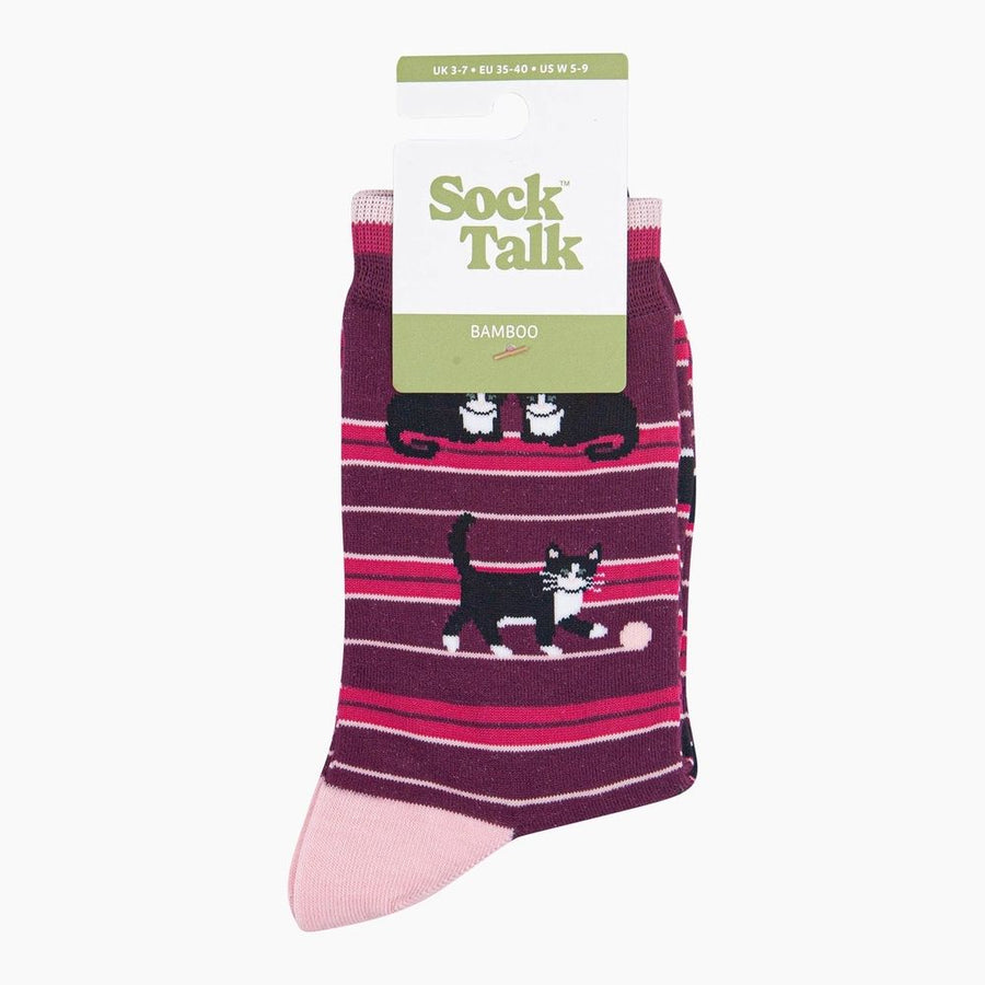A pair of Bamboo crew socks in a dark purple and pink striped pattern with black and white cat illustrations