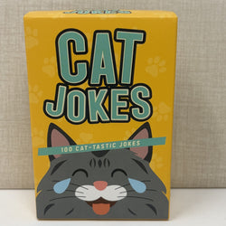 A yellow card game box titled 'CAT JOKES' with a cartoon gray cat face and the text '100 CAT-TASTIC JOKES' on a neutral textured background.