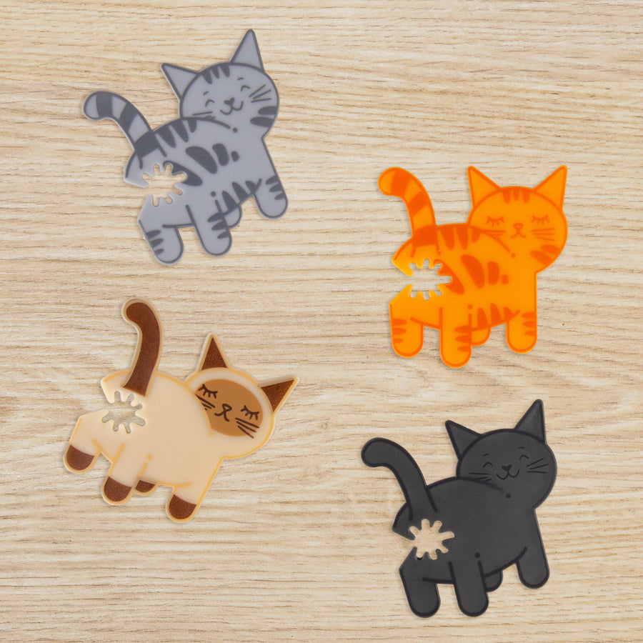 Four cat-shaped bag ties on a wooden surface
