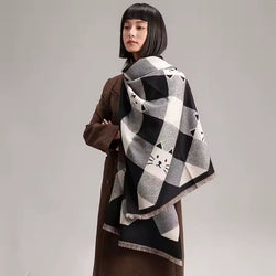 A woman wearing a large scarf with a black and white cat face geometric pattern