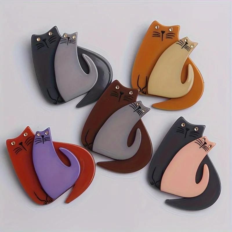 Set of cat-shaped brooches in various colours on a light grey background