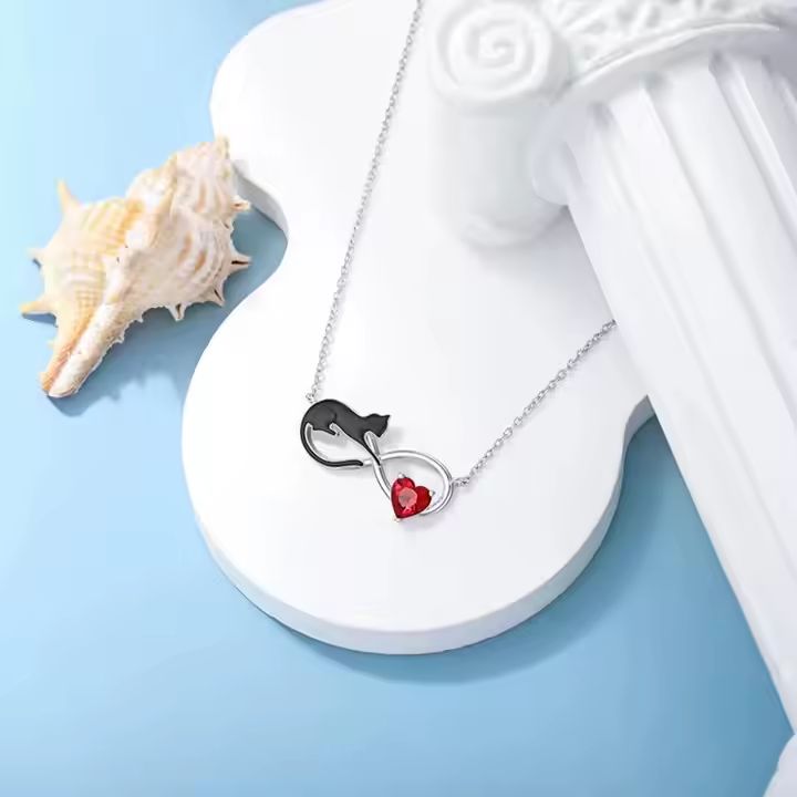 Necklace with cat and heart pendant on a white decorative base with a shell on a blue background