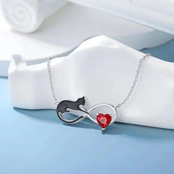 Sterling silver necklace with a silhouette of a cat and a red garnet crystal heart pendant on a chain