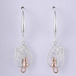 Silver and rose gold earrings on a light grey background