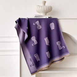 Purple fabric with illustrated with cats and a fringe