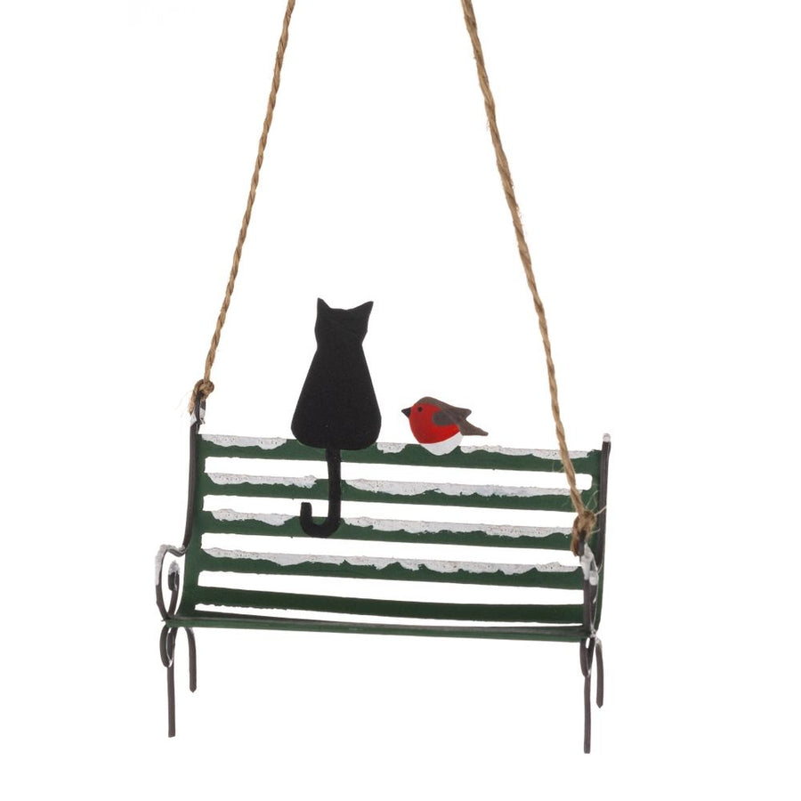 Hanging festive decoration featuring a cat and a robin sitting on the top rail of a snow covered bench