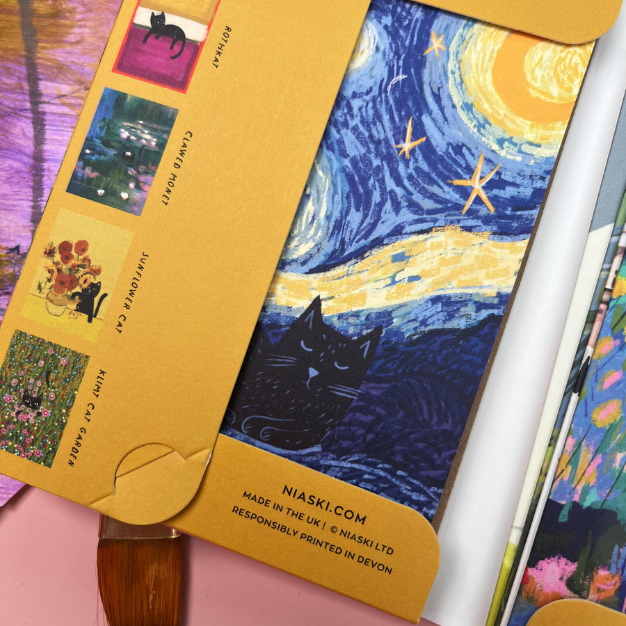 A close-up of a Van Gogh-inspired art print featuring a black cat under a swirling blue and yellow night sky