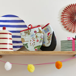 A pair of oven mitts with Christmas decorations and festive cats on a wooden shelf with other kitchen items