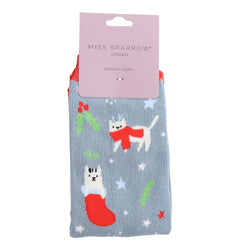 White kitty socks on a blue grey background. With silver stars and mistletoe details. 