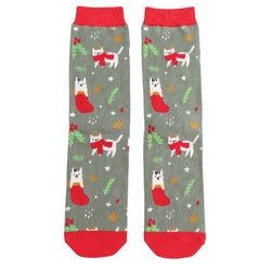 A pair of green grey socks decorated with white cats wearing red scarves. On a background of stars and mistletoe. 